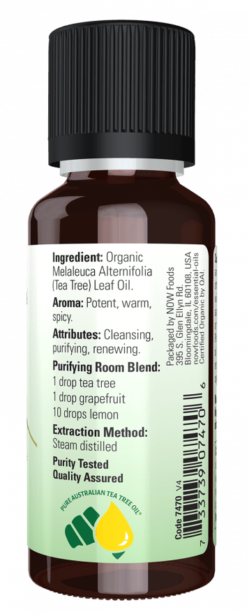 Bottle of tea tree leaf oil with label on a green background